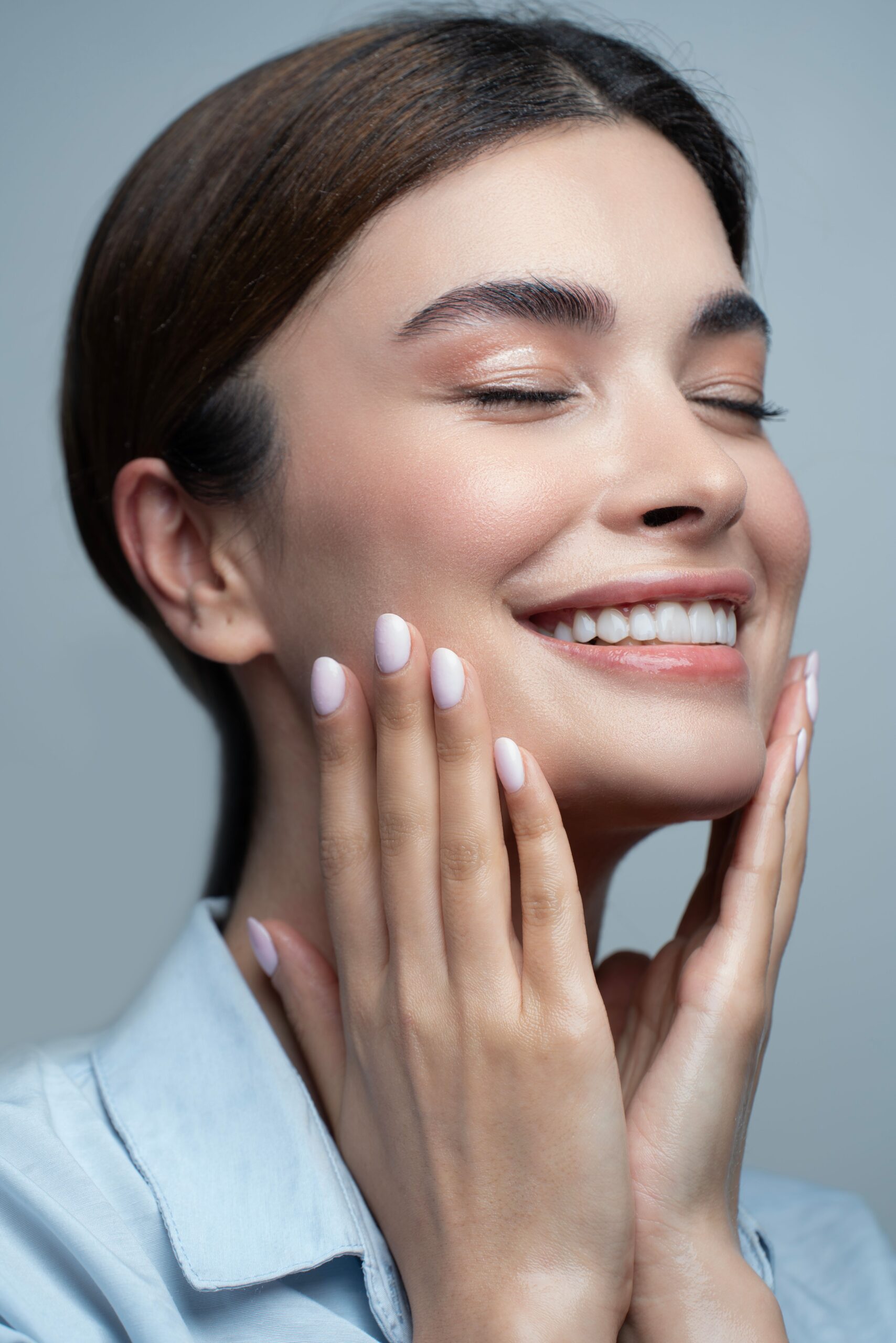 Confident woman with natural-looking skin in a bright, sophisticated aesthetics setting